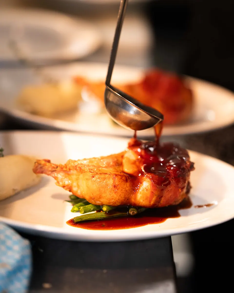 Maiale pork cutlet wrapped in prosciutto, glazed with jus and served with braised beans