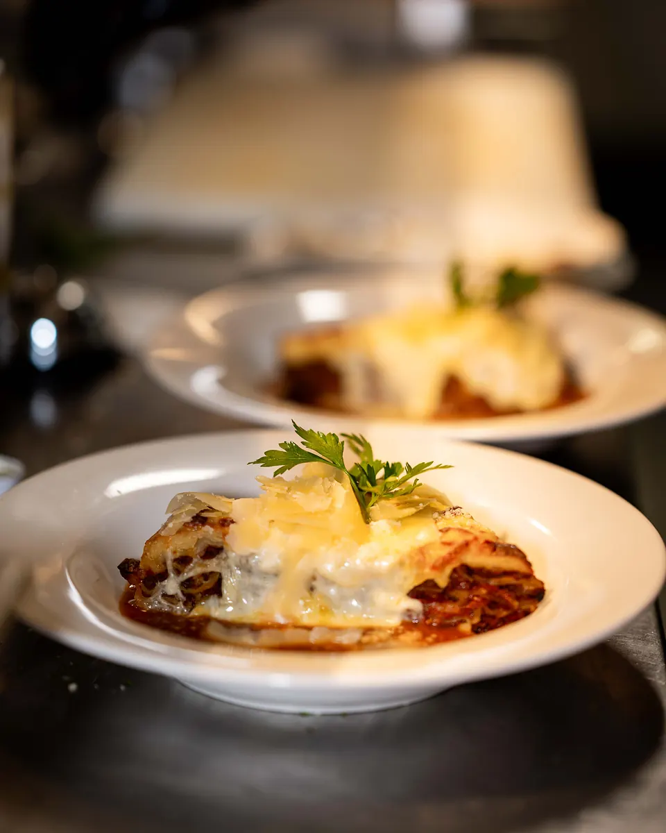 Traditional beef lasagna baked with bolognese sauce and parmigiano, finished with parsley