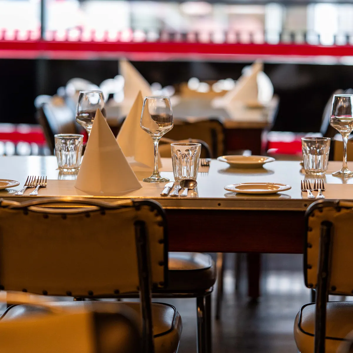 Grappino's modern-retro dining room set for a group, with folded napkins and wine glasses