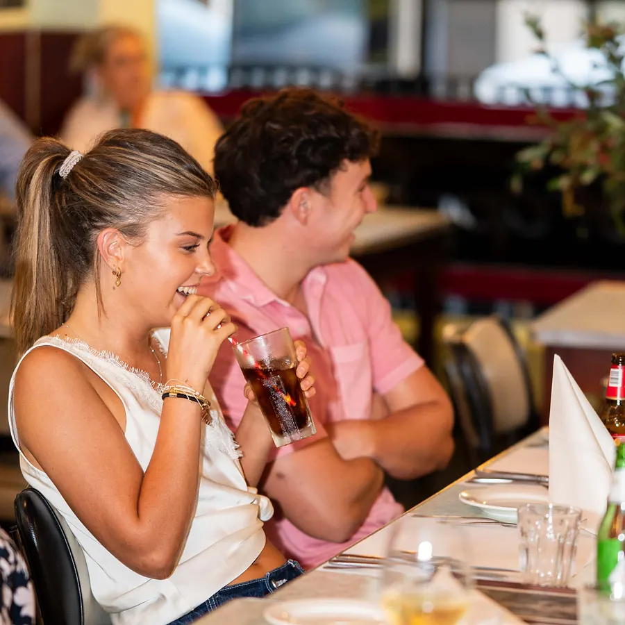 Friends sharing a laugh over dinner at Grappino