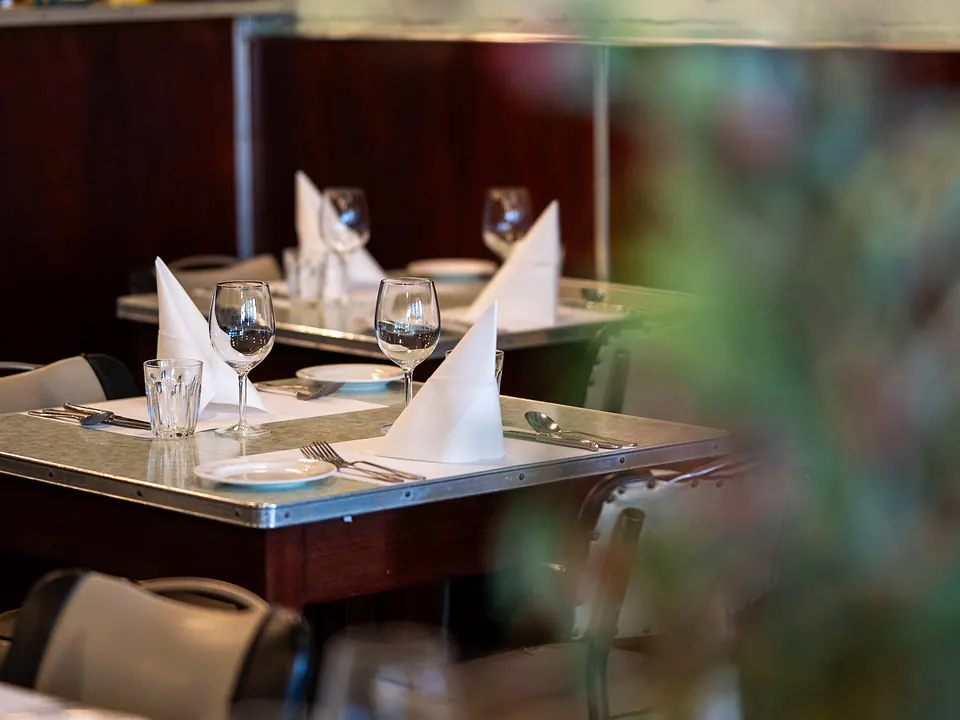 Tables set for a group dinner beneath Grappino's vintage wall collection