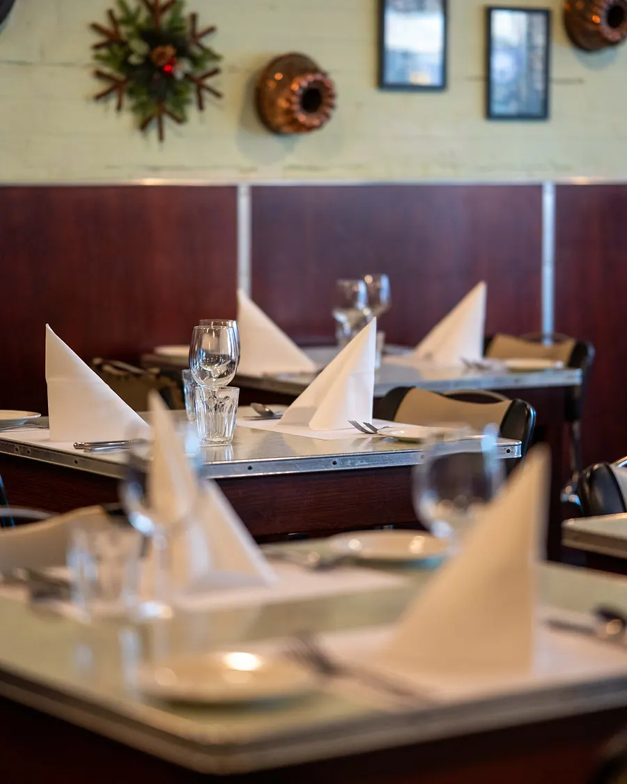 Grappino's dining room on Given Terrace: set tables, timber panelling and vintage kitchenware on the walls