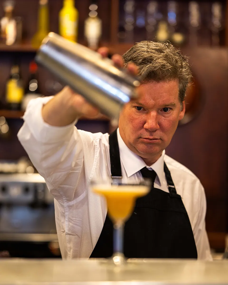 A Grappino bartender pouring a shaken cocktail at the bar