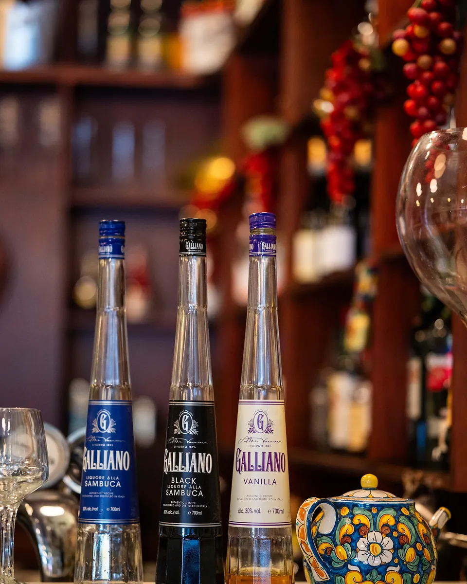 Italian liqueur bottles lined up on the shelf behind the Grappino bar