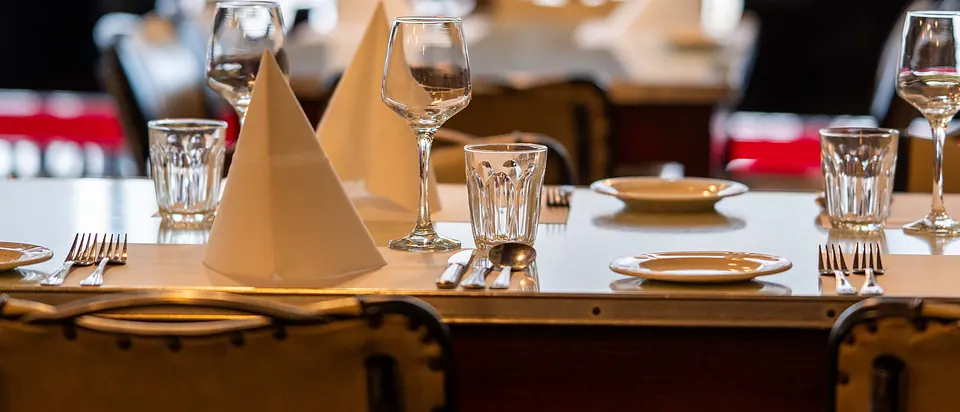 Grappino's dining room set for a group, with folded napkins and wine glasses
