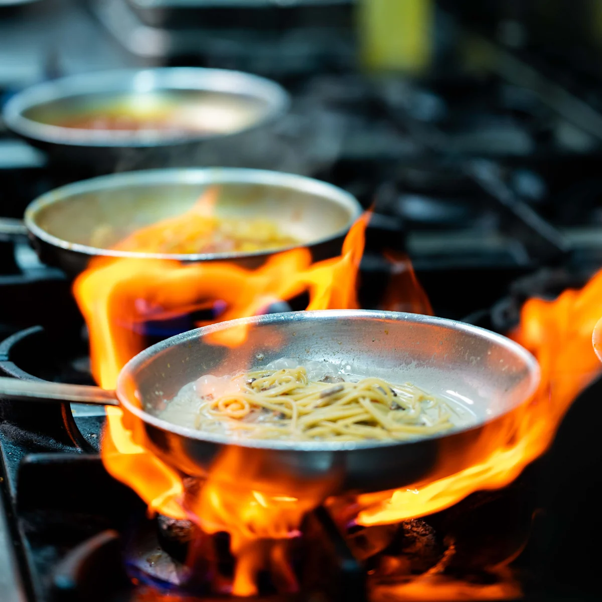 Spaghetti tossed in a flaming pan on the stove at Grappino Trattoria, Paddington