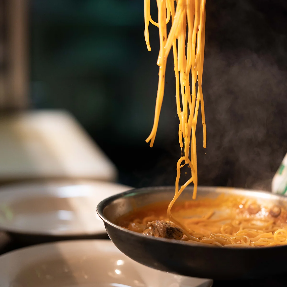 Spaghetti lifted from the pan in a cloud of steam in the Grappino kitchen