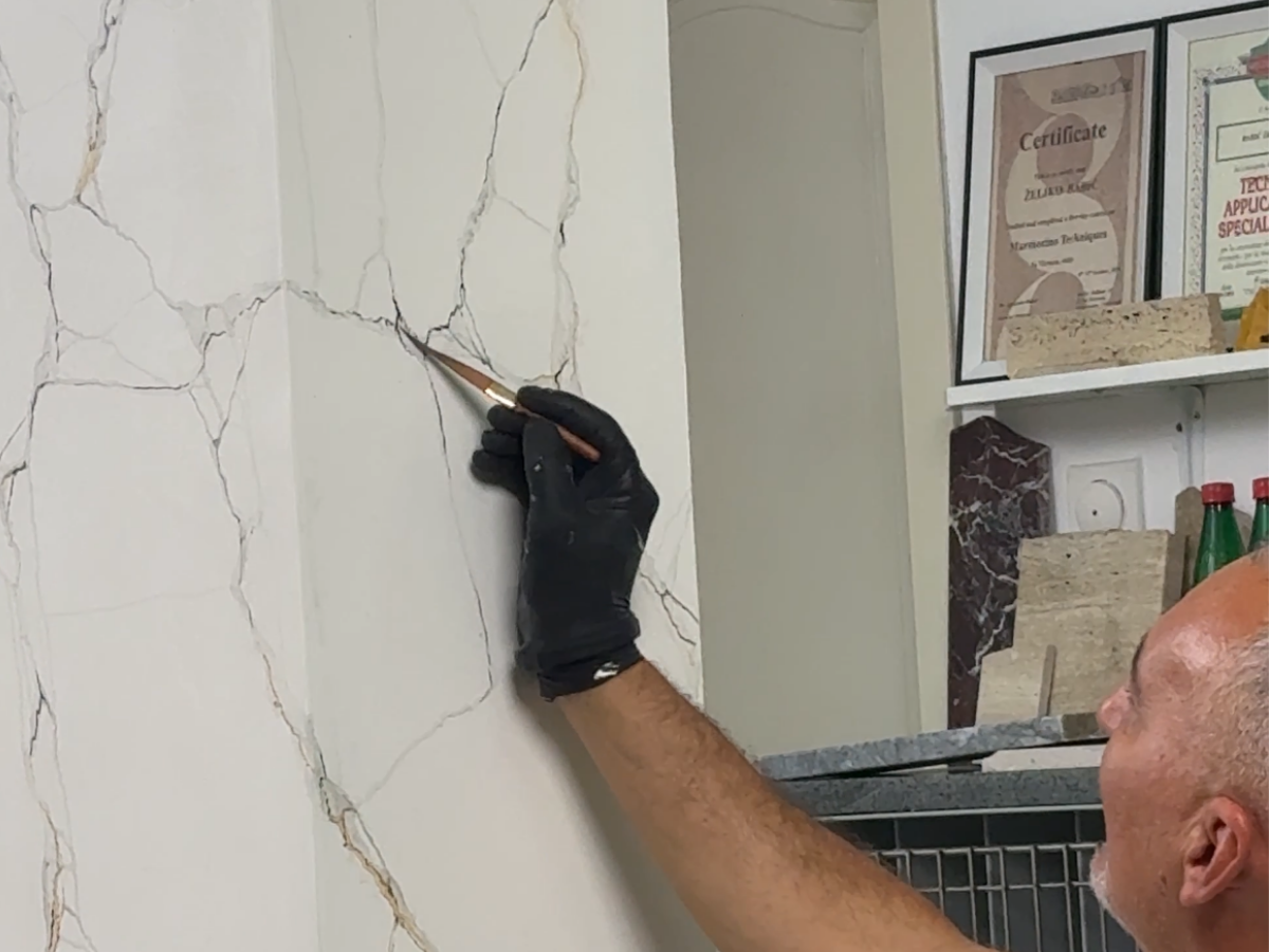 Applying veining to a marble effect wall with a fine brush