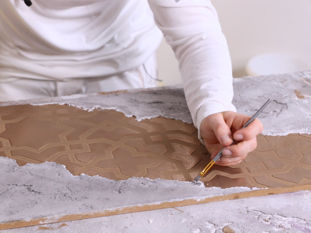 Close-up video tutorial showing plaster being worked on a wall