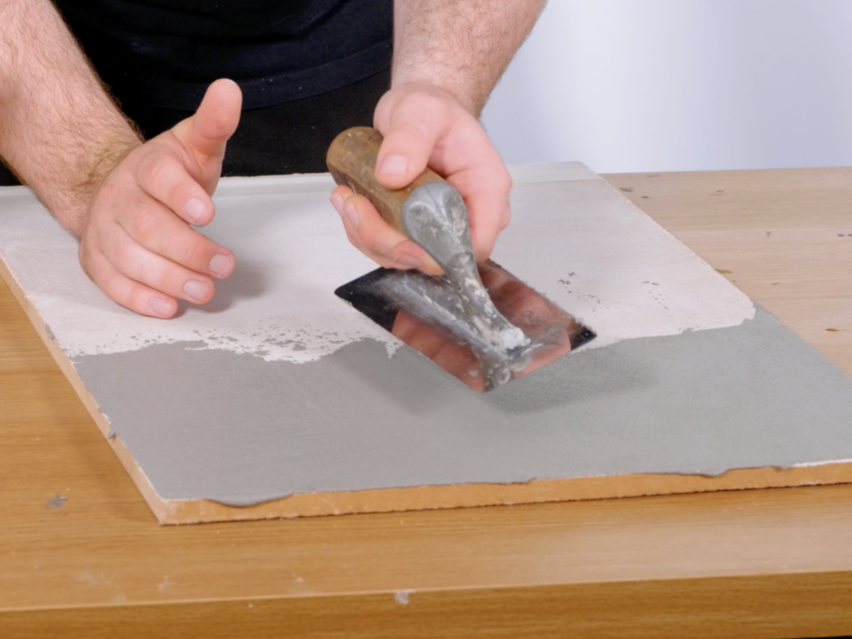 Close-up of a steel trowel laying Venetian plaster