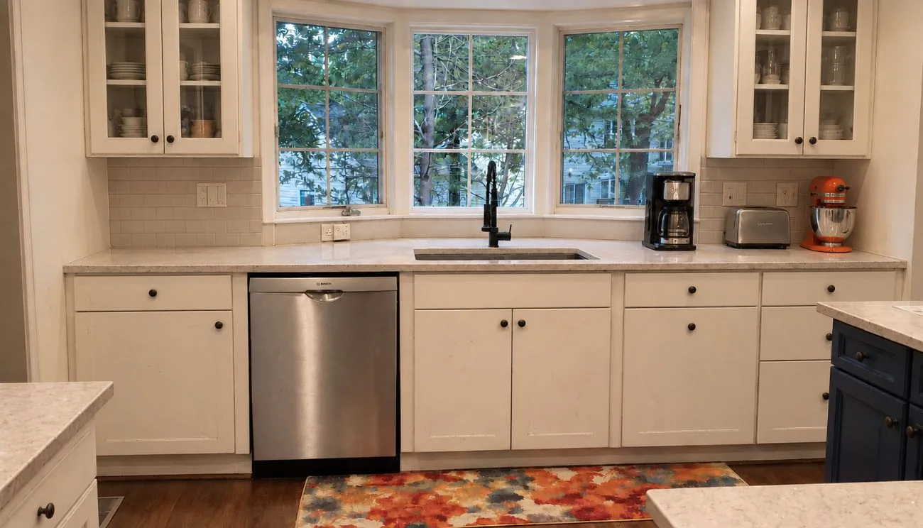 Kitchen before remodel: old cream cabinets and worn countertop