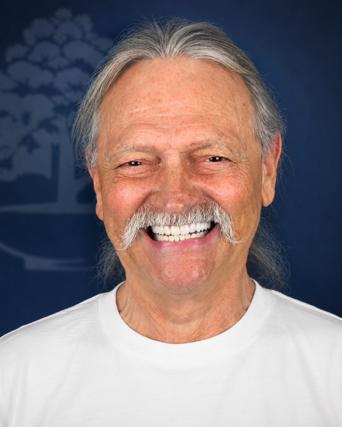 Smiling patient with a gray mustache, portrait after dental implant treatment