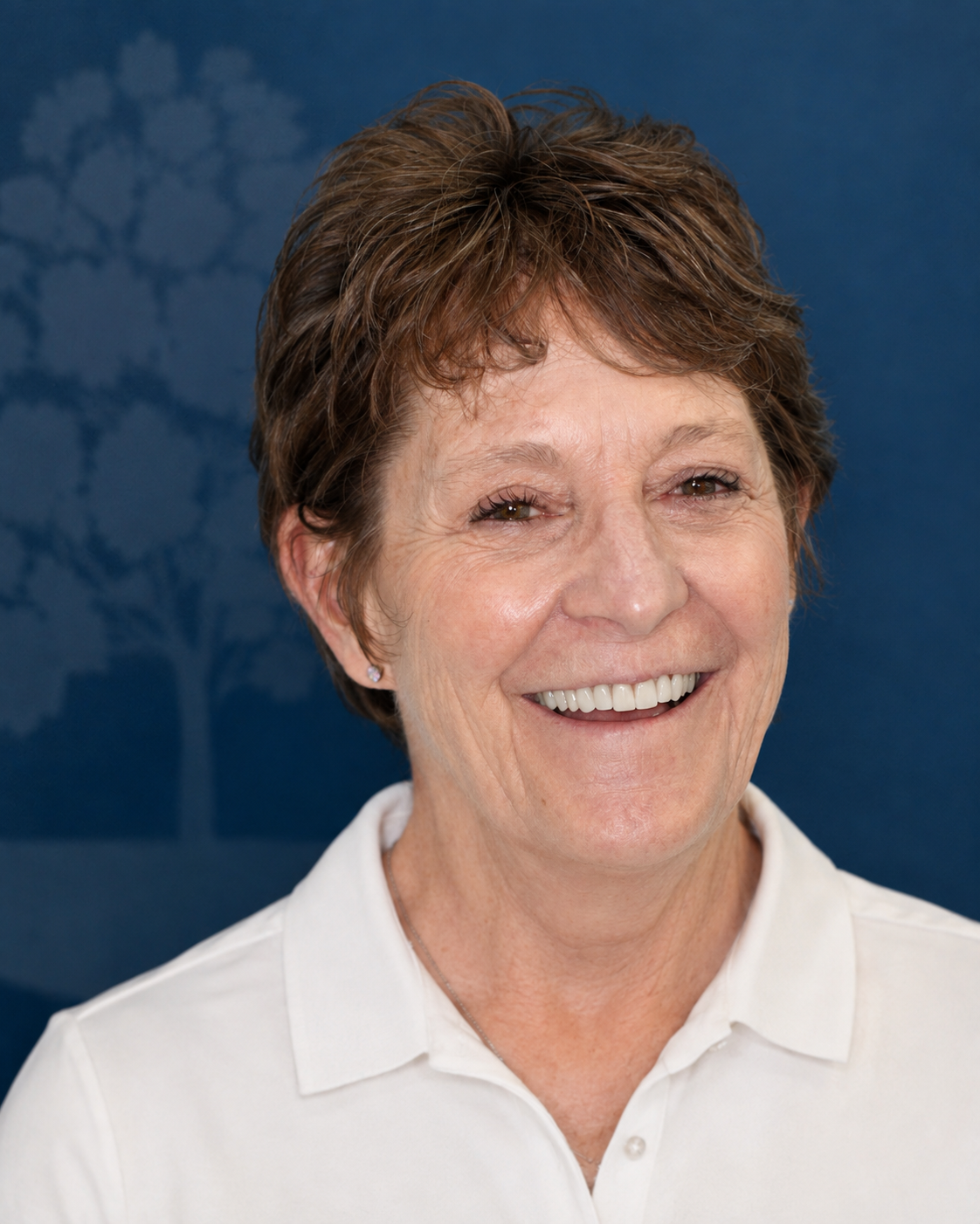 Smiling patient with short brown hair, portrait after dental implant treatment