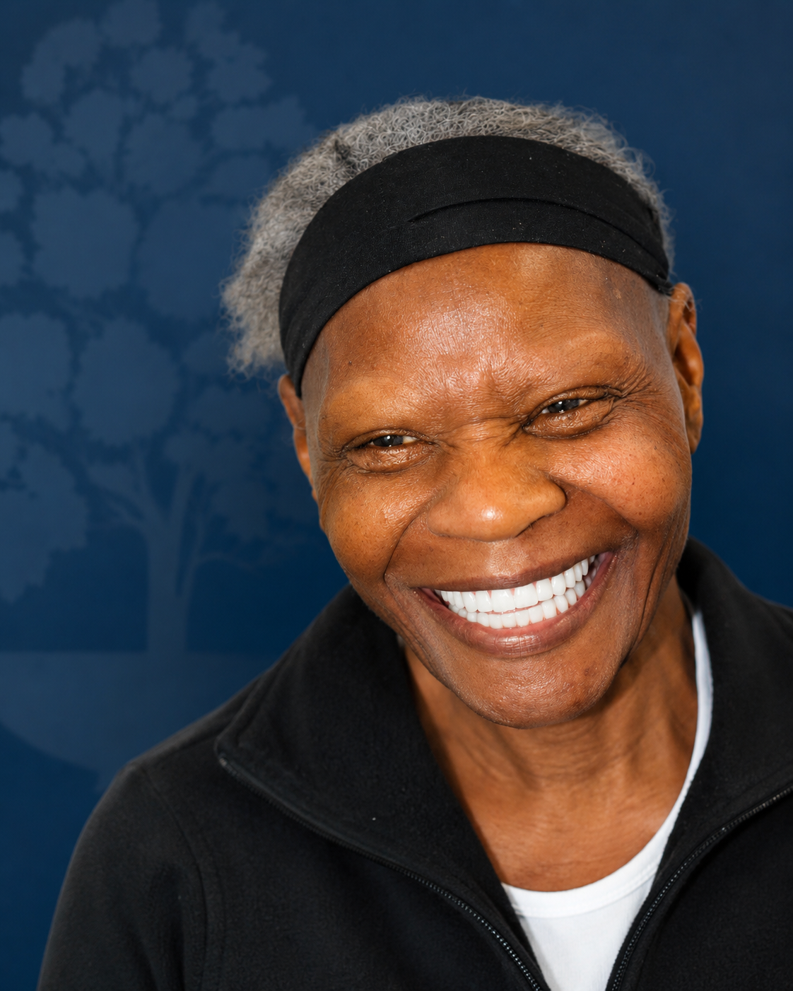 Smiling patient wearing a headband, portrait after dental implant treatment