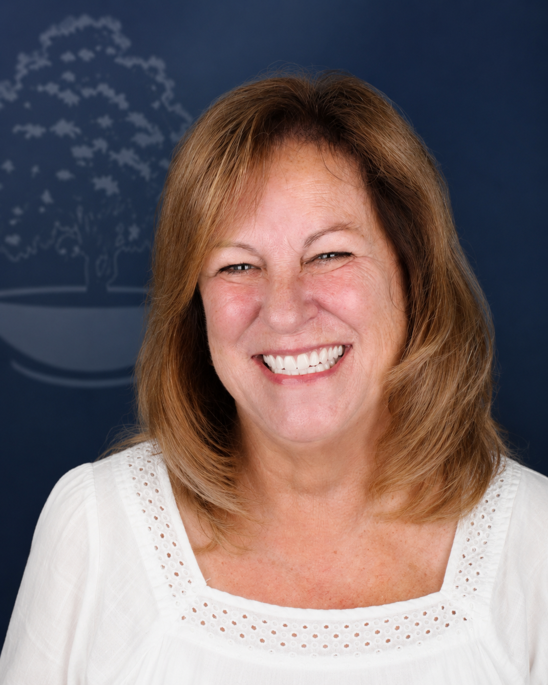 Smiling patient with shoulder-length auburn hair, portrait after dental implant treatment