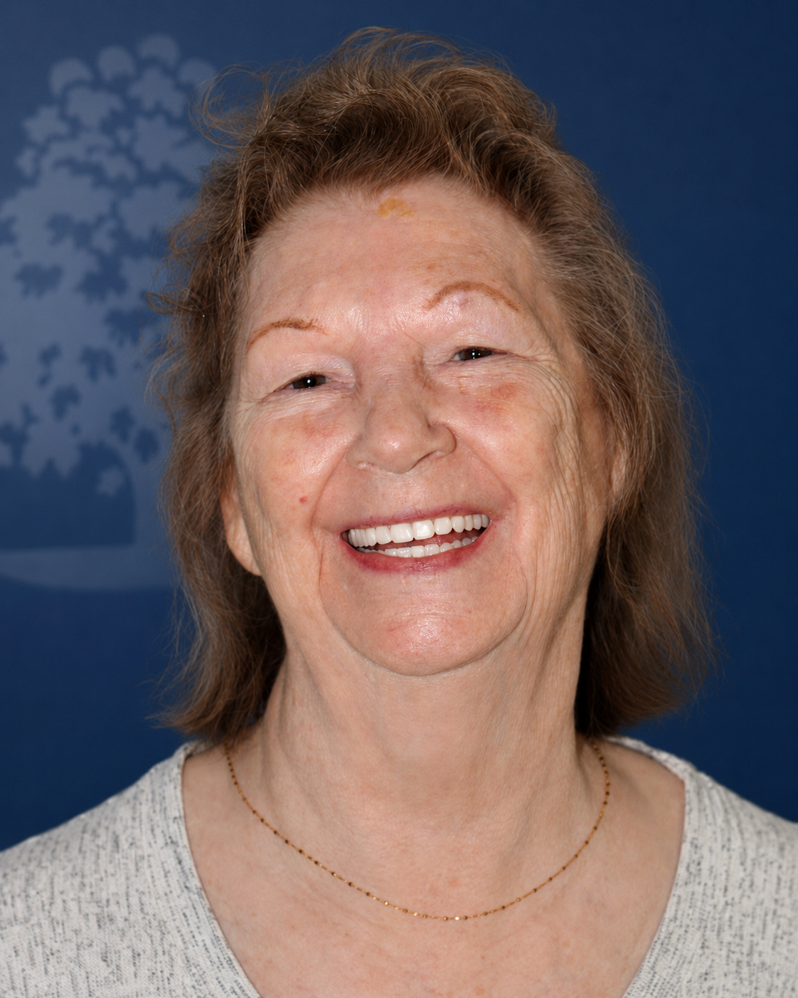 Smiling patient with brown hair, portrait after dental implant treatment