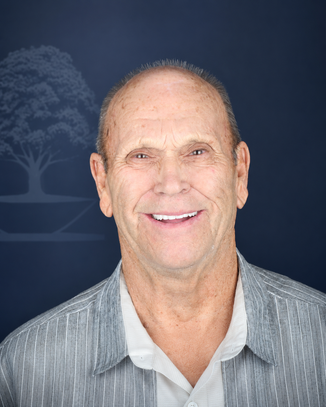 Smiling patient with a shaved head, portrait after dental implant treatment