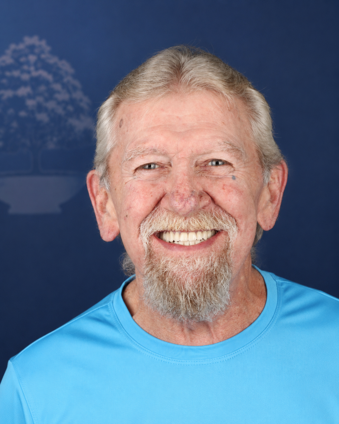 Smiling patient with a gray beard, portrait after dental implant treatment