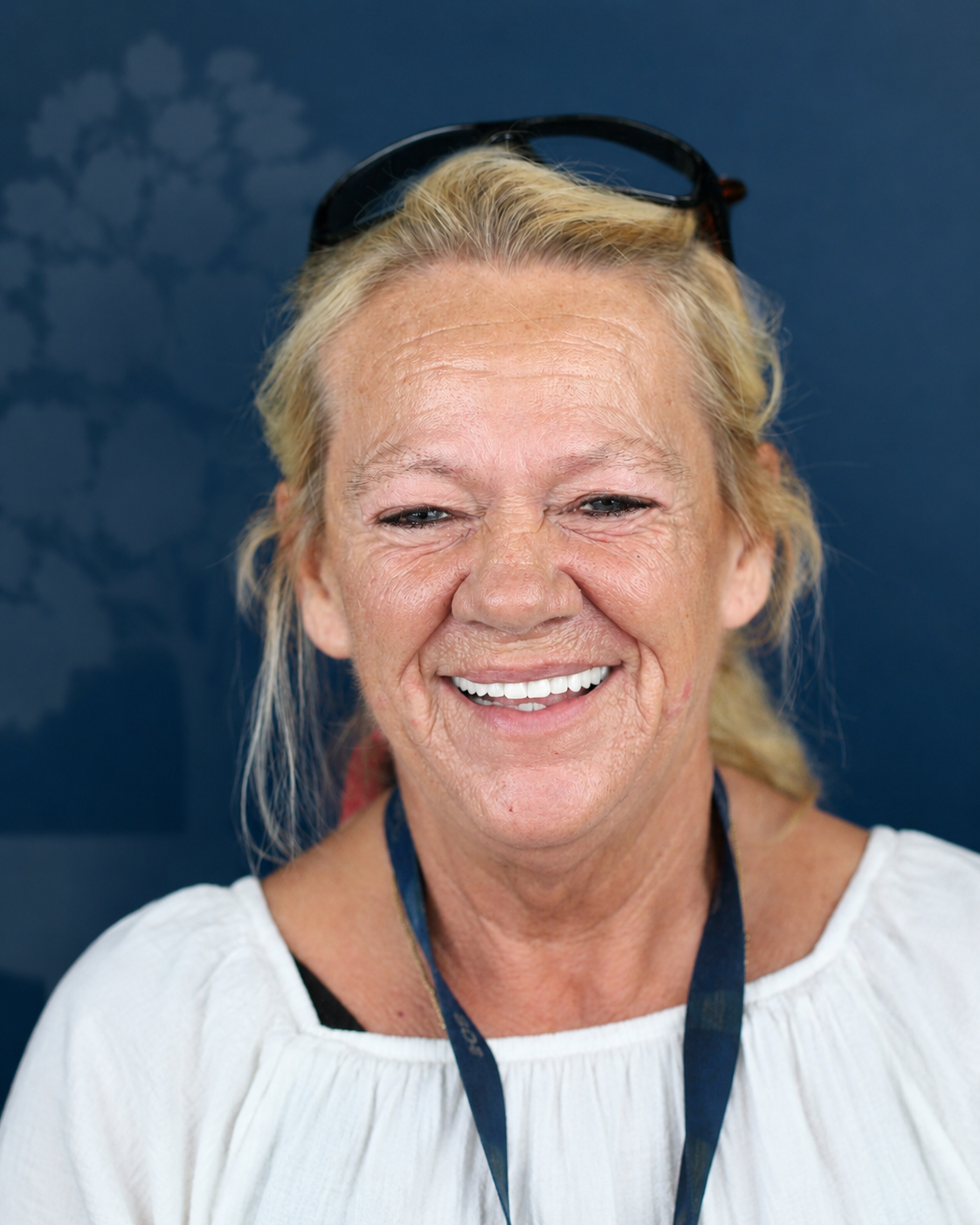 Smiling patient with blonde hair and sunglasses, portrait after dental implant treatment