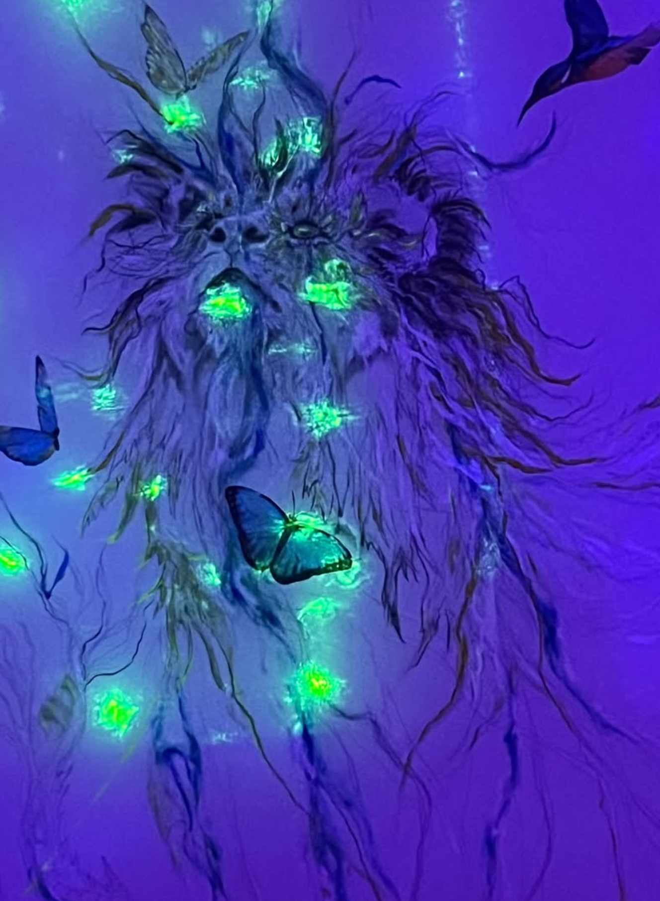 Lion glowing green under ultraviolet light with butterflies and a kingfisher