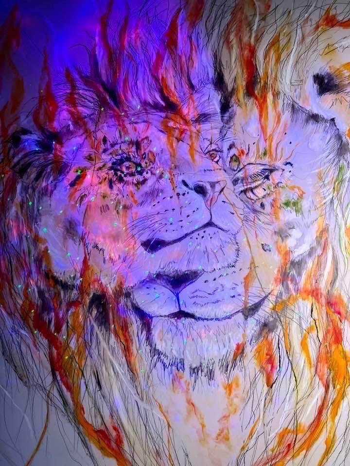 Lion wreathed in orange flame under violet light