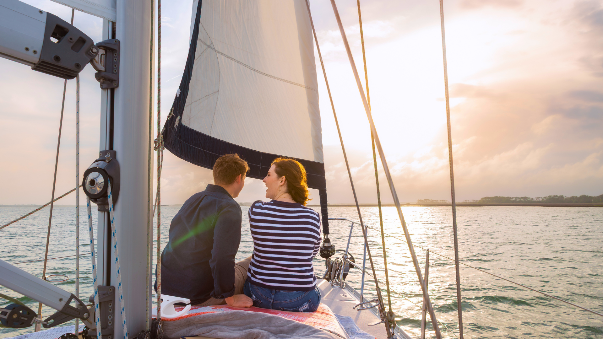 Romantic sunset sailing near Charleston SC with couple watching ocean horizon during golden hour