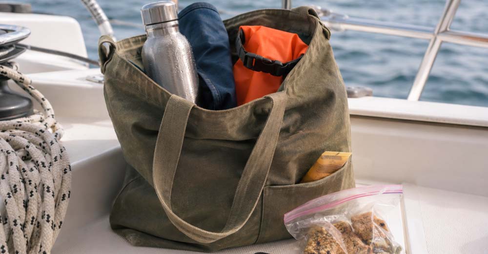 Sailing charter packing essentials with dry bag water bottle sunscreen and phone Sailing charter packing essentials with dry bag water bottle sunscreen and phone