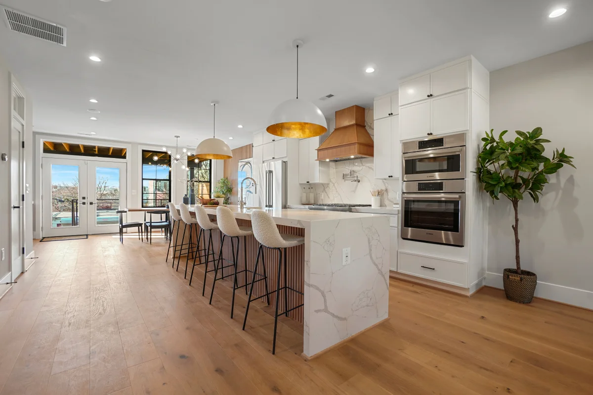 Open-concept kitchen remodel by RemodelX featuring elegant bar area and wood accents