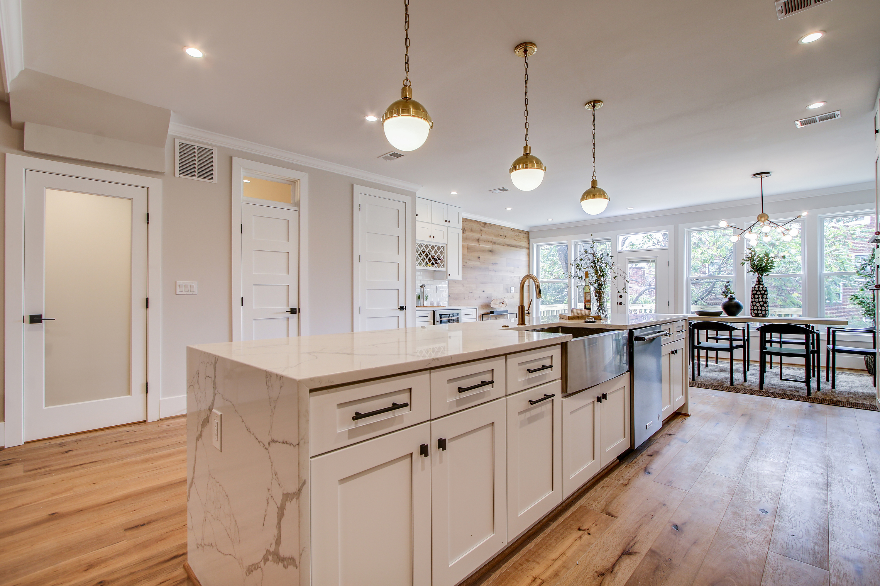 Open-concept kitchen remodel featuring REMODELX design with white cabinetr