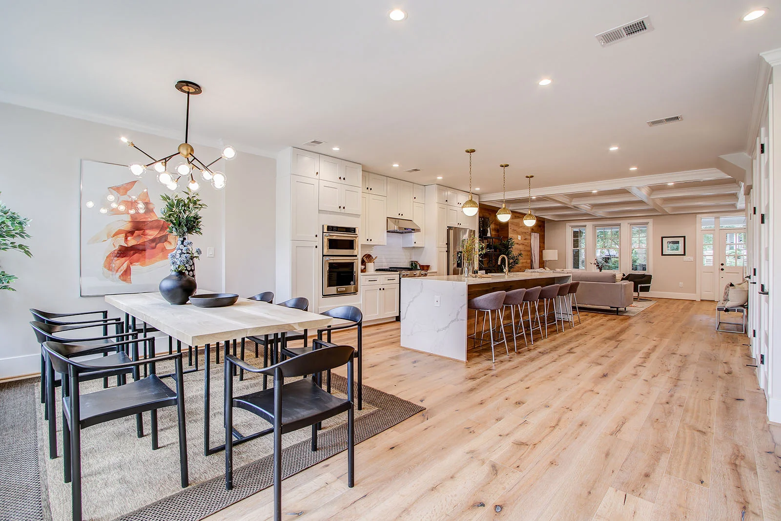 Modern open-concept kitchen and dining area by RemodelX