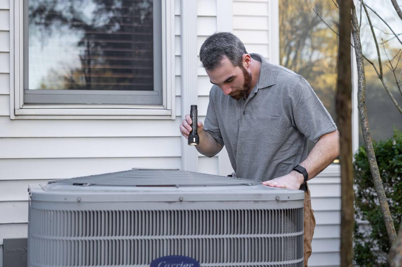 Technician servicing an outdoor air conditioner