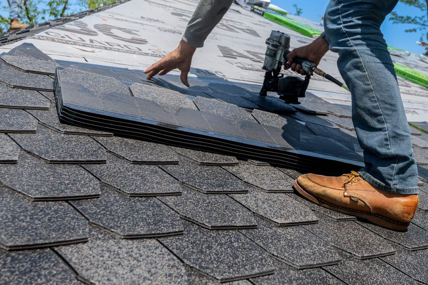 Roofer installing shingles