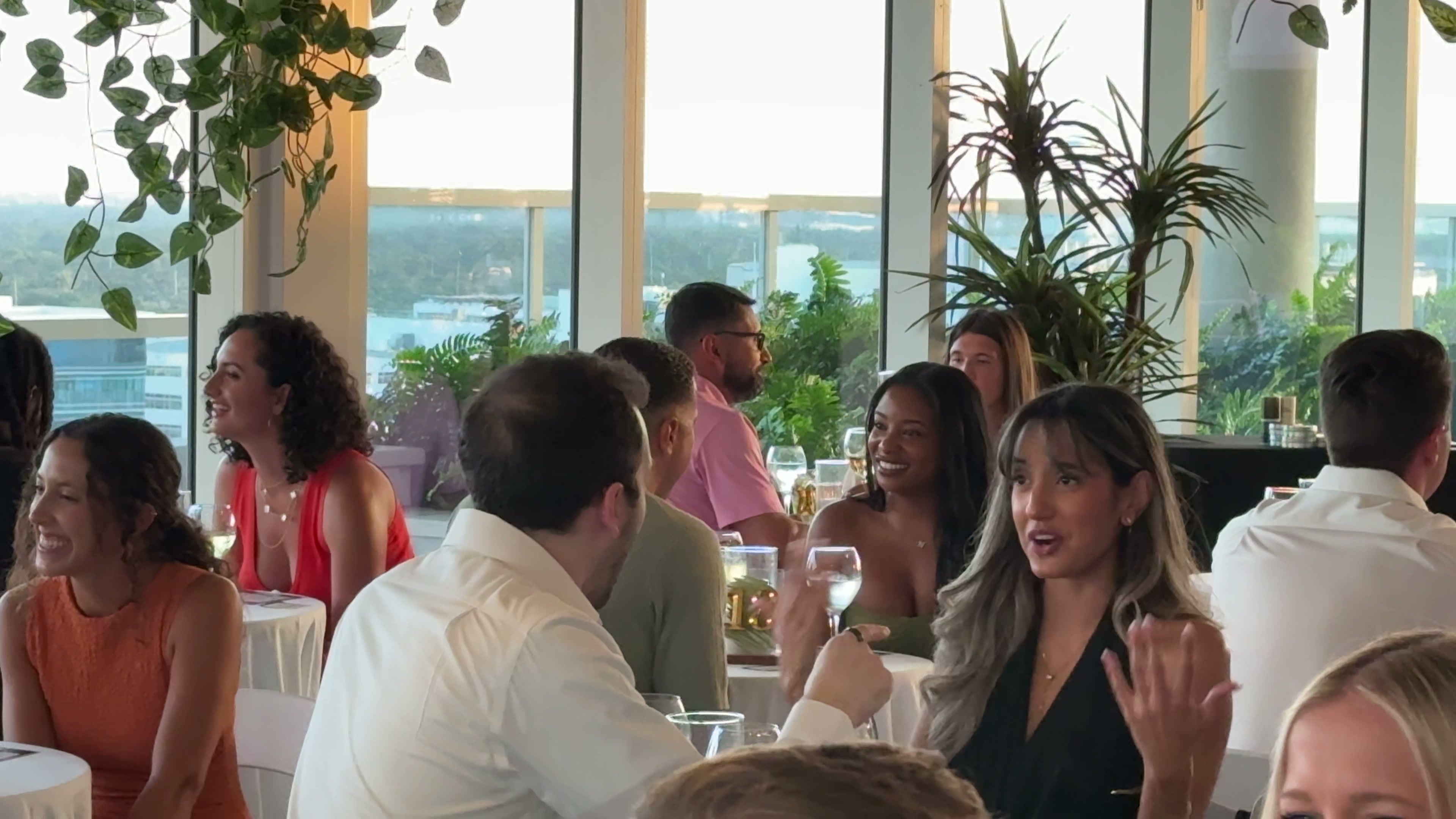 Women laughing at tables during a MITW event