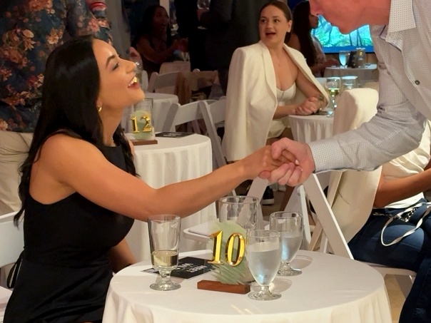 Man greeting woman with handshake as he rotates to her table