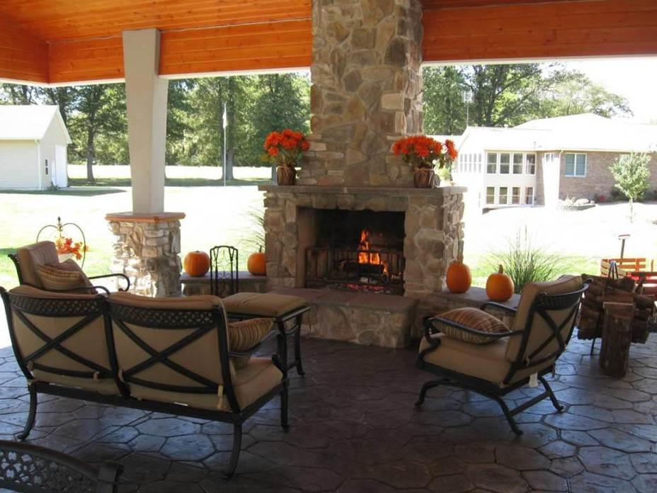 A custom outdoor stone fireplace integrated into a covered patio living space