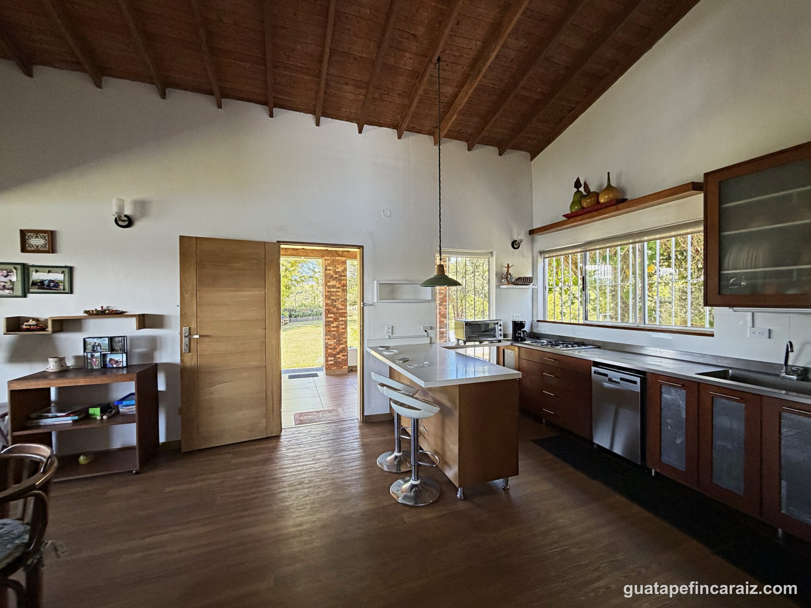 Open kitchen with island counter and cathedral wood-beam ceiling