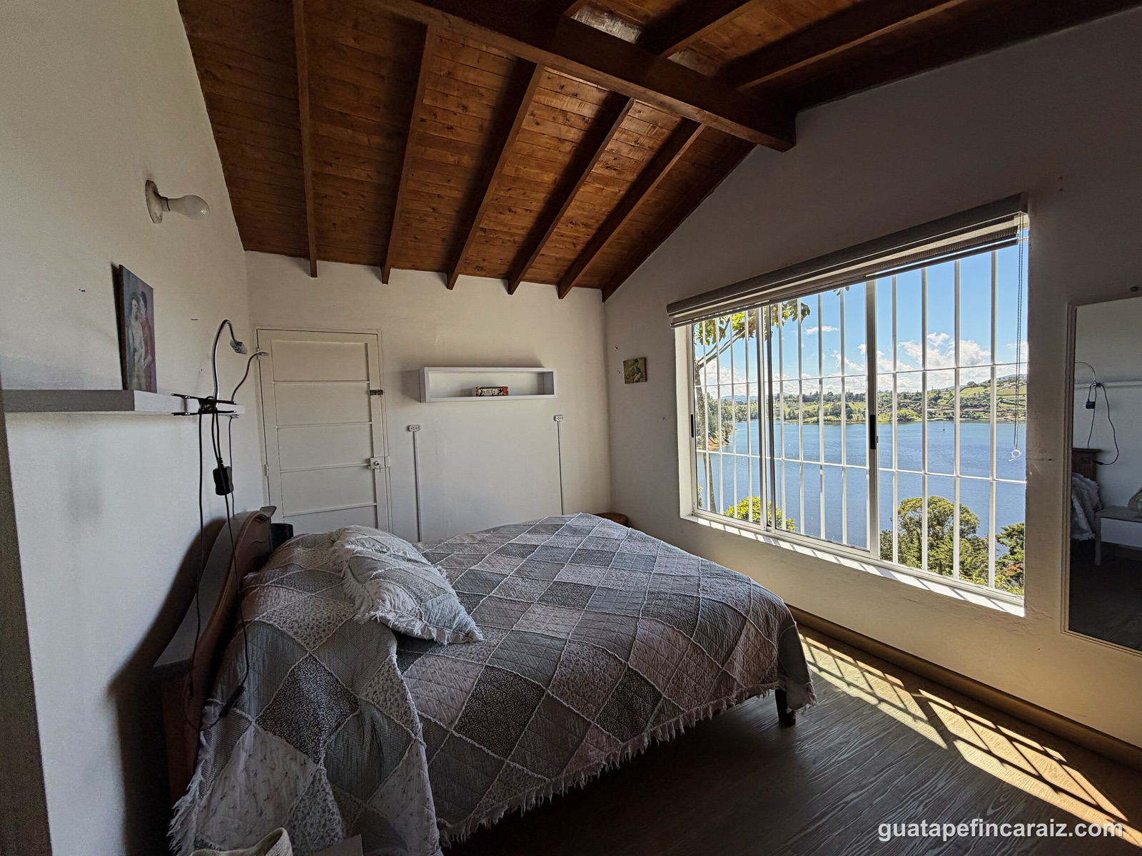 Bedroom with cathedral wood-beam ceiling and reservoir view