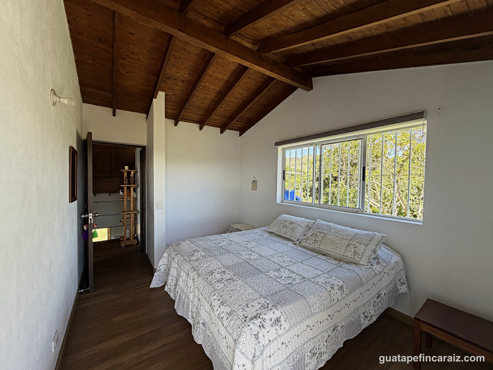 Bedroom with reservoir view and carved wood mirror