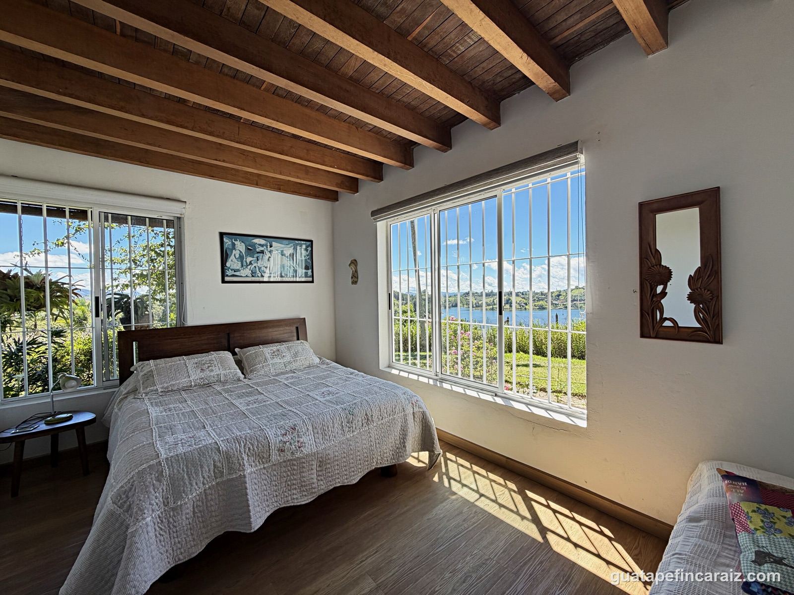 Primary bedroom with lake-view window and iron security bars