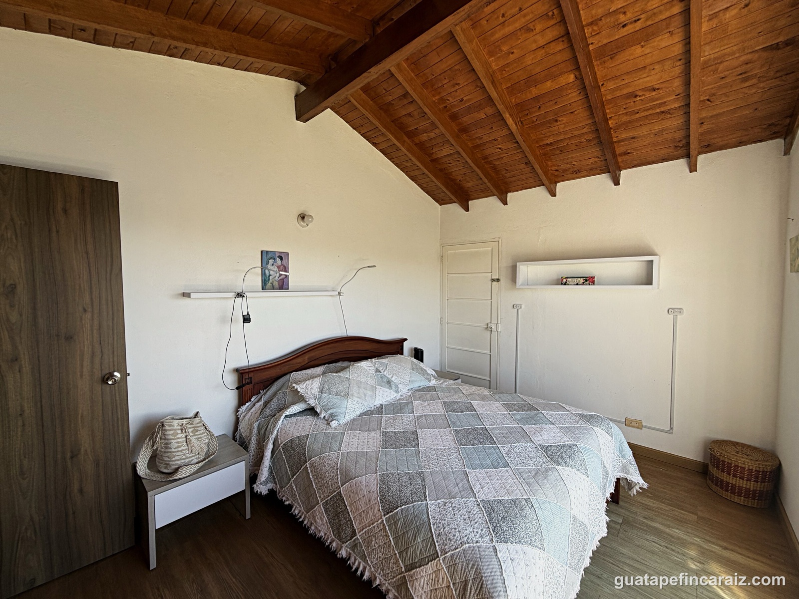 Bedroom with dark wood headboard and garden view