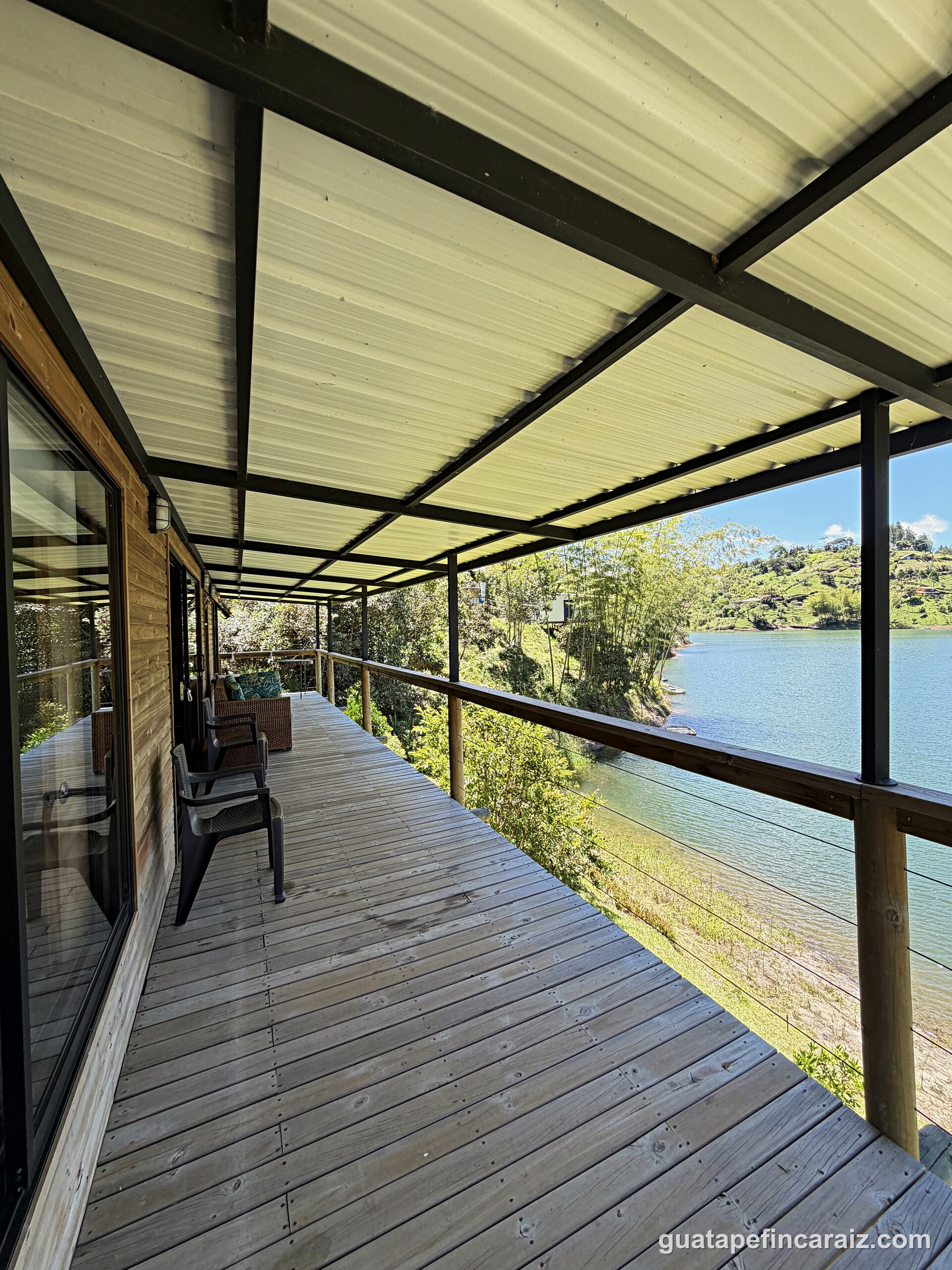 Covered deck at Cabaña del Embalse with wide views over the Guatapé-El Peñol reservoir and surrounding hills