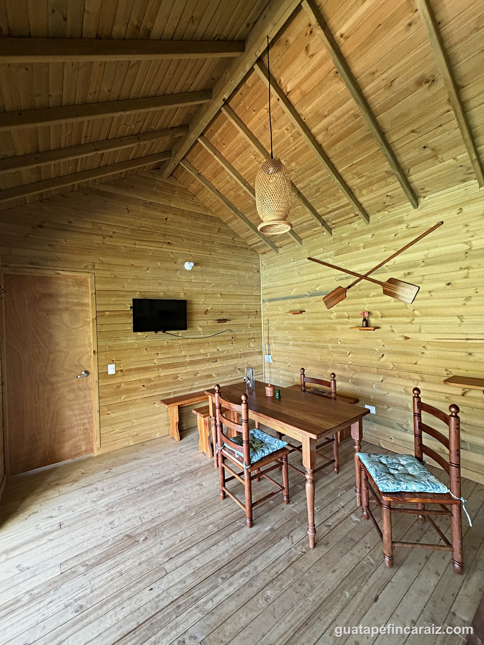 Living and dining area at Cabaña del Embalse with cathedral wood ceilings and lake-house decor
