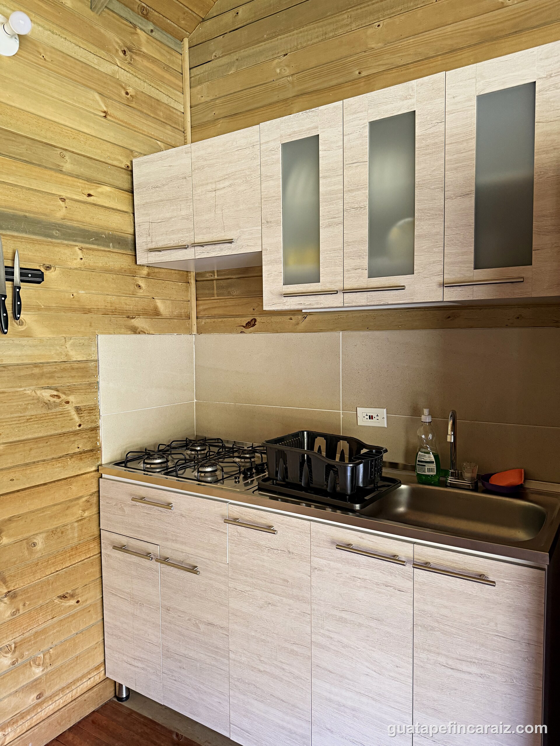 Kitchen at Cabaña del Embalse with gas stove, stainless sink, and light-wood cabinetry