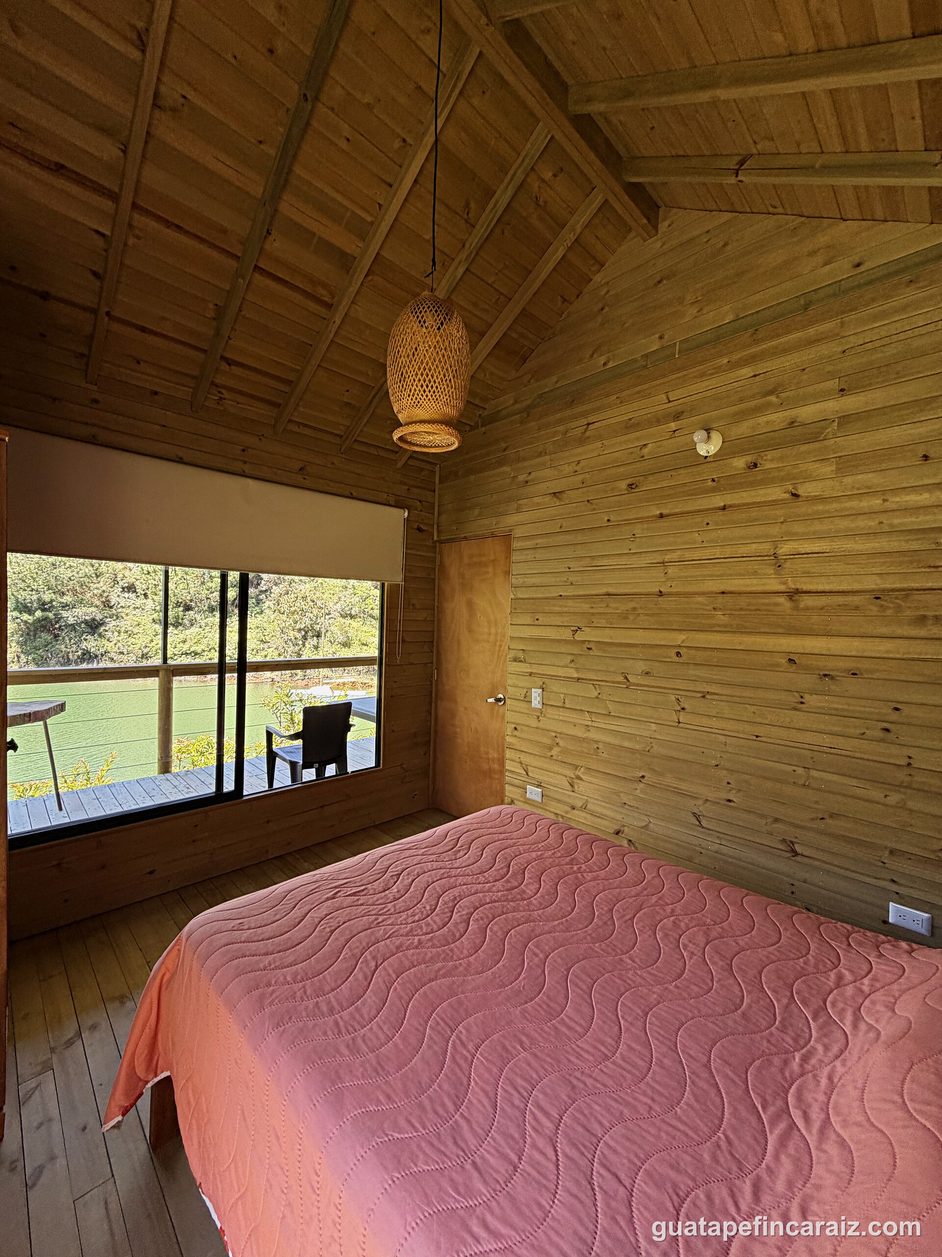 Primary bedroom at Cabaña del Embalse with a window looking out to the deck and the reservoir