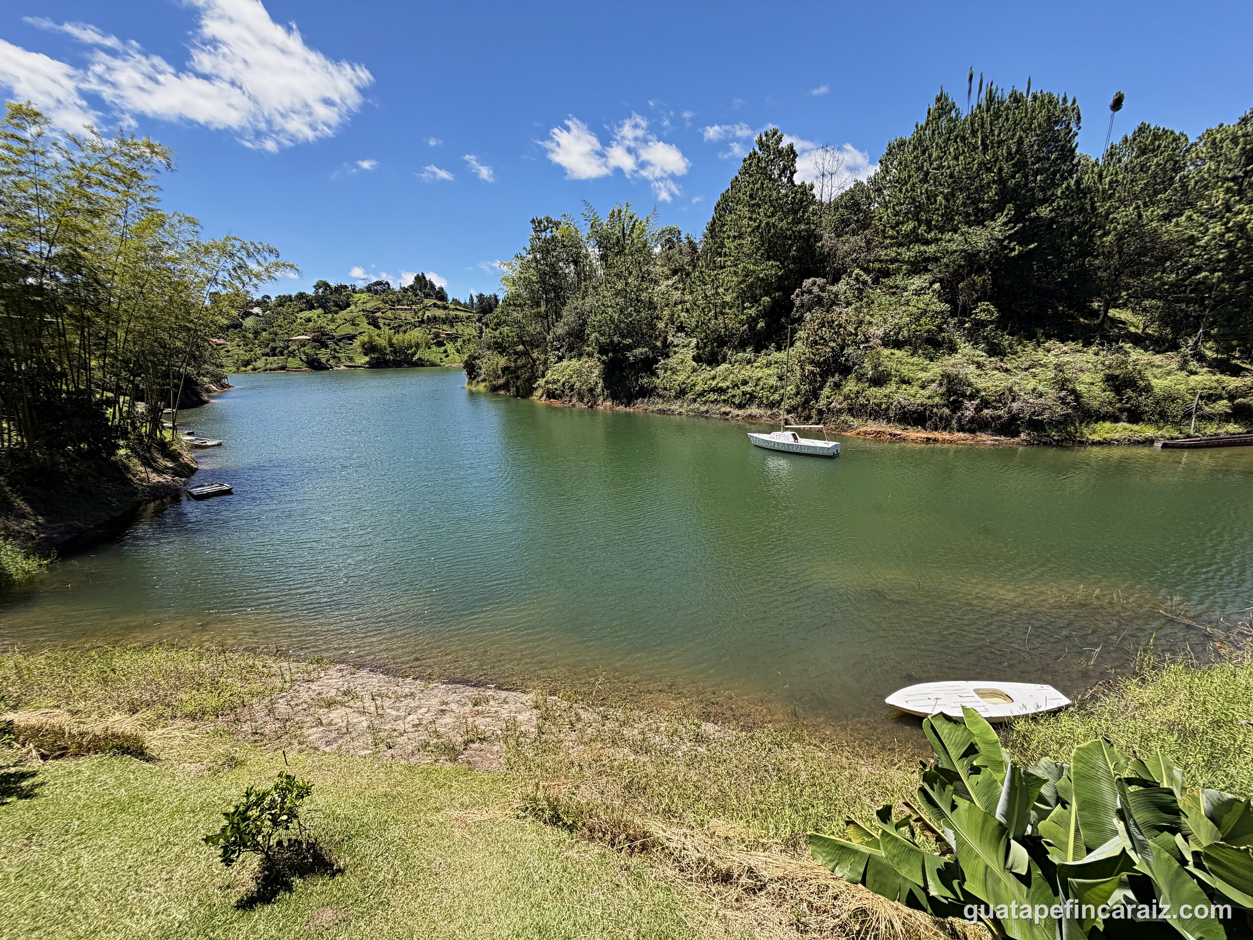 Boats moored on the Guatapé-El Peñol reservoir near Cabaña del Embalse, surrounded by green hills