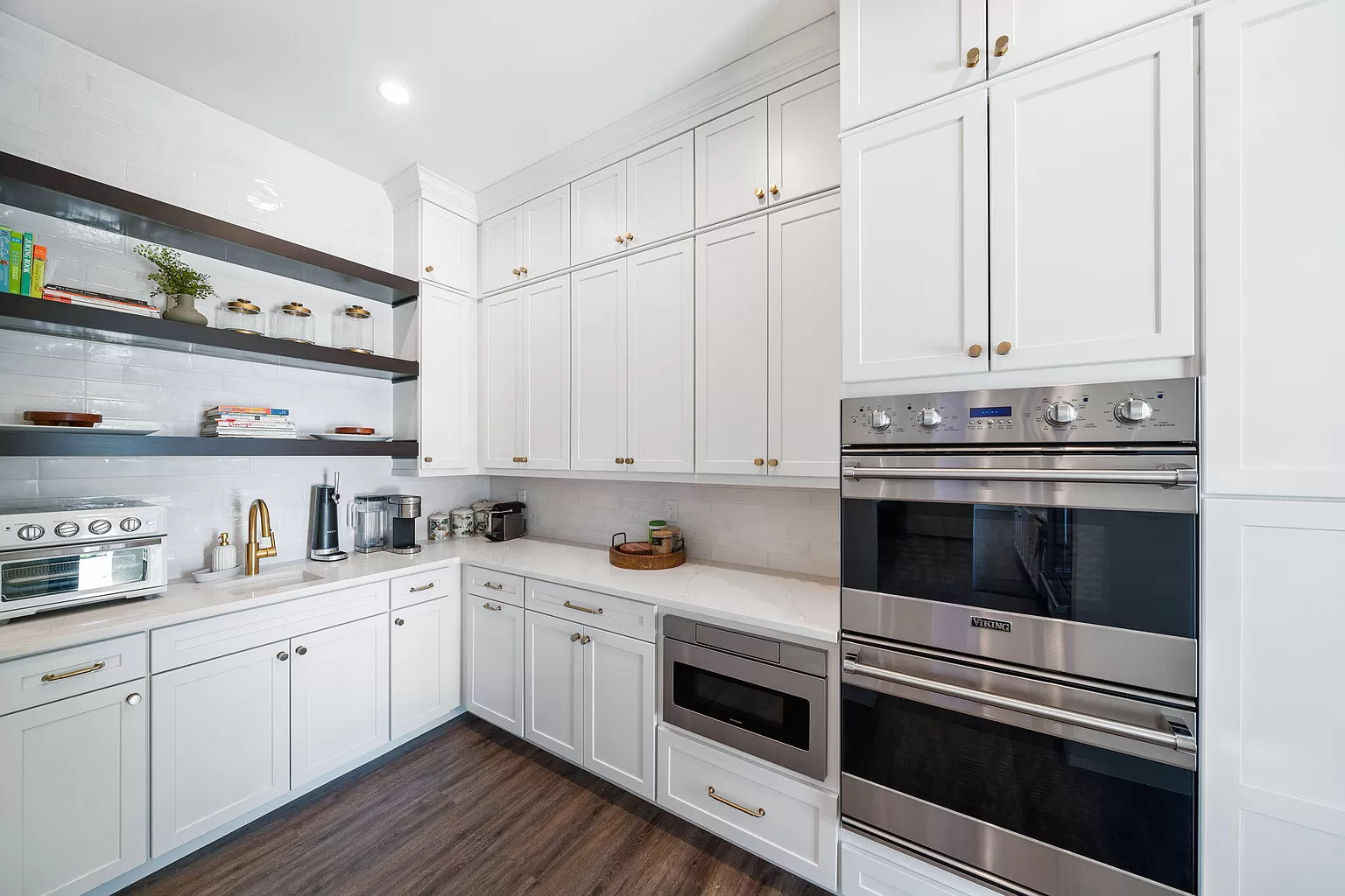 A sparkling clean kitchen with shiny countertops, clean cabinets, and gleaming stainless steel appliances in a South Florida home.