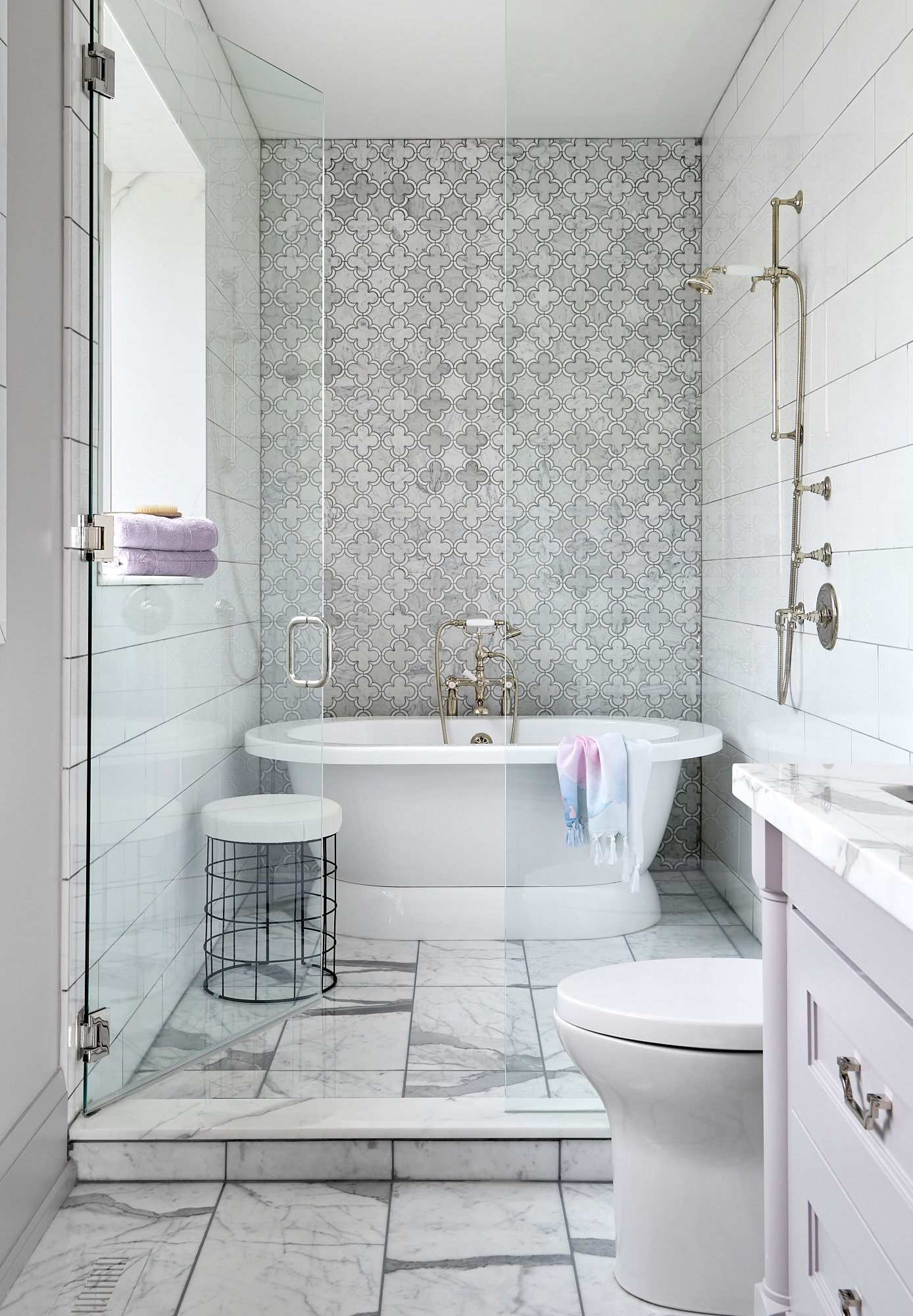 A bright, modern bathroom with gleaming white tiles, spotless glass shower door, and shiny chrome fixtures, representing a professionally cleaned bathroom in South Florida.