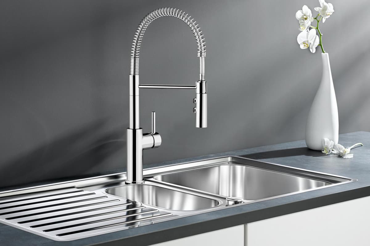 A spotless stainless steel kitchen sink and shiny faucet after cleaning, highlighting the results of effective kitchen maintenance.