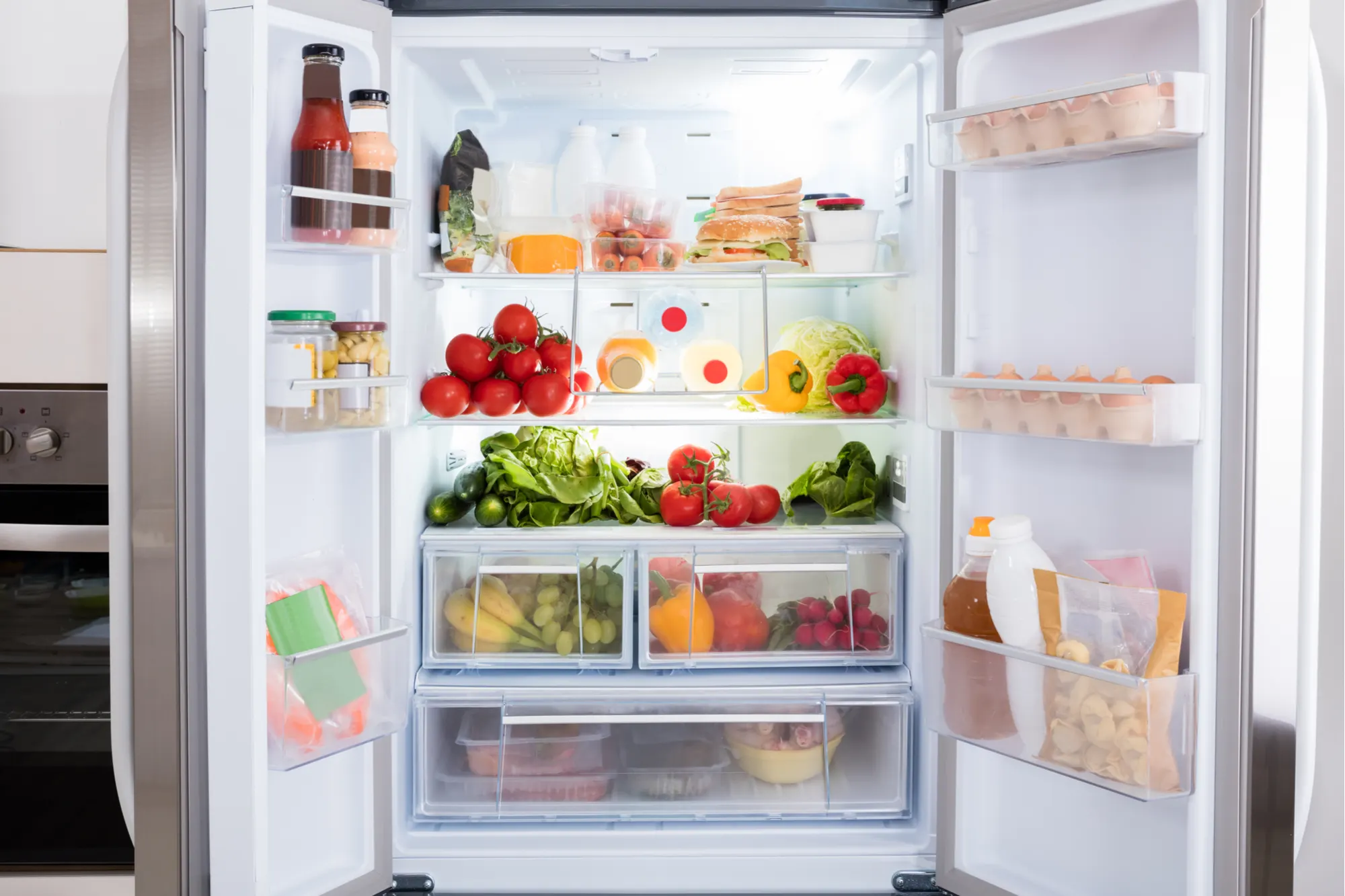 An organized and clean refrigerator interior with fresh produce and neatly arranged items, showcasing proper kitchen hygiene.