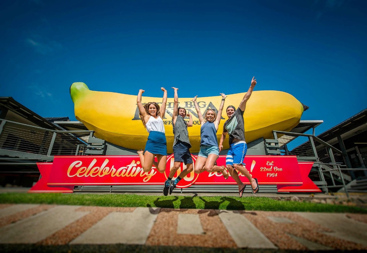 Four friends jumping for joy in front of the Big Banana in Coffs Harbour